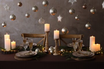 Christmas table setting with burning candles and festive decor