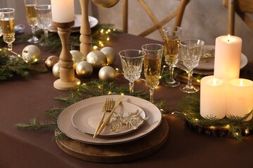Christmas table setting with burning candles and festive decor