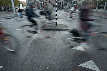 Cyclists in motion crossing streets of Amsterdam downtown. Bicycle congestion on thecity  streets concept