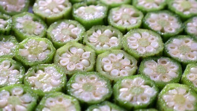 Fresh green sliced okra vegetables (lady fingers, gumbo) circle rotation close up
