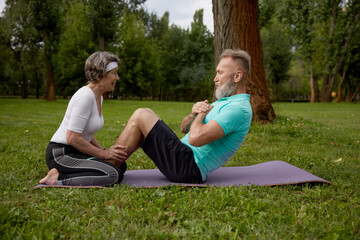 Fototapeta premium Happy married couple of retirees doing training workout in park