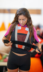 young caucasian girl putting on life jacket before going out kitesurfing kayak water sports