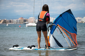 Naklejka premium Practicing windsurfing in the Mediterranean is a pleasant way to stay healthy by doing sports.