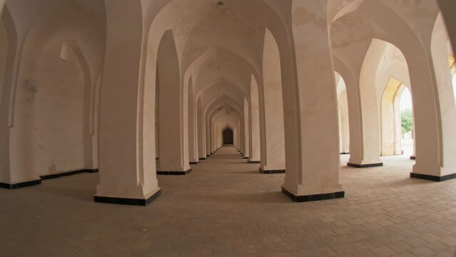 Passage between columns and arches in the Mir-i-Arab Madrasa complex.