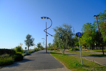Adriatic promenade in Rimini, Emilia-Romagna with street lamps in the shape of the letter R on a sunny day © Kate