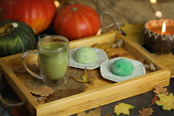 Colorful japanese sweets daifuku or mochi sliced. Sweets close up on the plate with cup of matcha tea