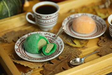 Colorful japanese sweets daifuku or mochi sliced. Sweets close up on the plate with cup of coffee
