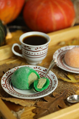 Colorful japanese sweets daifuku or mochi sliced. Sweets close up on the plate with cup of coffee