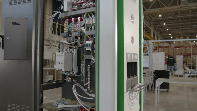 Internal part with wires of charging station cabinet at industrial park. Inner section containing cables within charging hub at warehouse