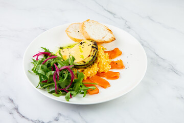 a mix of salmon, arugula salad, white bread and baked avocado with cheese side view