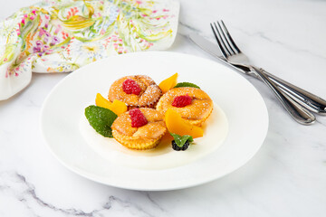 muffins with peach, raspberry, black berry and mint covered with powdered sugar, side view