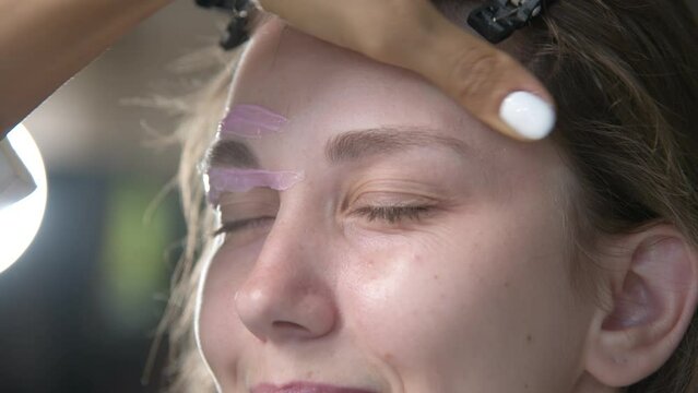 Hair removal, beauty and health concept. A young girl is getting an epilation procedure. A processional beauty worker is making depilation with hot wax