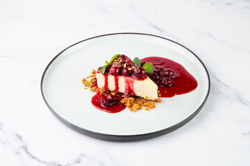 top view of cheesecake with juicy berries and mint on a white plate 