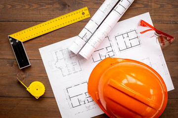 Construction helmet on drawing blueprints for house designing and architect plan