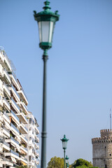 Fototapeta na wymiar View of a lantern, residential buildings and the famous White Tower, also known as Lefkos Pyrgos in Thessaloniki Greece