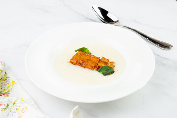 porridge with mint leaves and pieces of meat in sweet and sour sauce side view