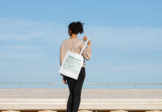 Mockup of woman holding customizable tote bag over shoulder