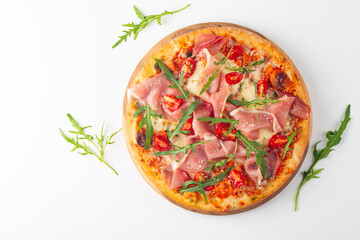 Pizza with prosciutto, ham, arugula, tomatoes, pesto, cheese and parmesan. Italian cuisine. 