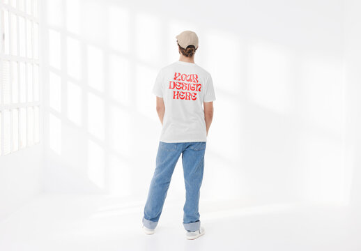 Mockup of man wearing customizable t-shirt standing in studio, rear view