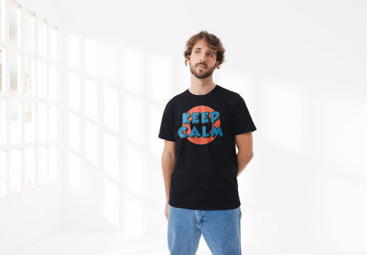 Mockup of man wearing customizable t-shirt in studio next to window