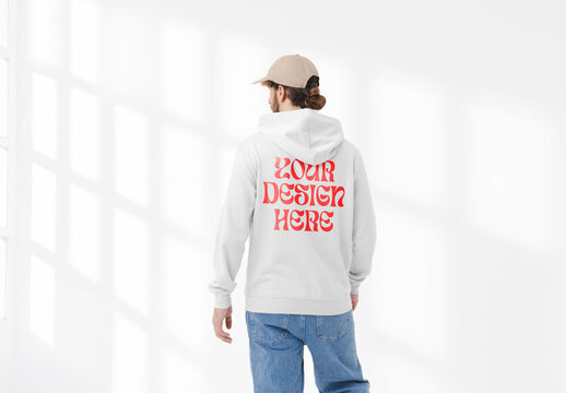 Mockup of man wearing customizable hoodie and cap, rear view