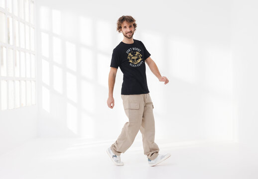 Mockup of man wearing customizable t-shirt in studio with leg forward