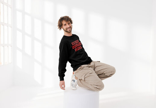 Mockup of man wearing customizable sweatshirt balancing on plinth