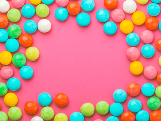 Fototapeta na wymiar multicolored round candy on a pink background