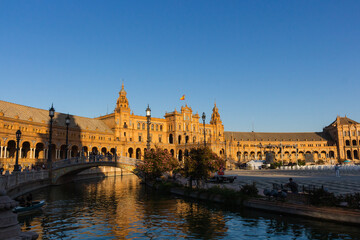 Seville, Spain, September 11, 2021: The Spanish Steps in Seville or 'Plaza de España', where the main building of the Ibero-American Exhibition of 1929 was built. Spanish flag at sunset.