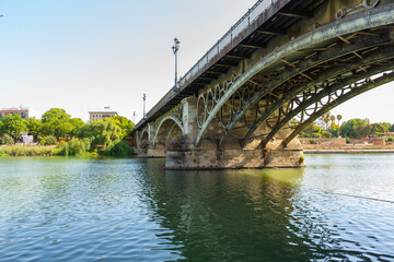 The Puente de Isabel II, Puente de Triana or Triana Bridge, is a metal arch bridge in Seville, Spain, that connects the Triana neighbourhood with the centre of the city.
