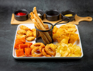 beer set with nuggets, breaded onion rings, fries and sauces side view