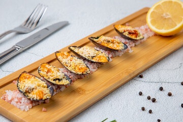 oysters scallops with red sea salt and citric acid on a wooden tray side view