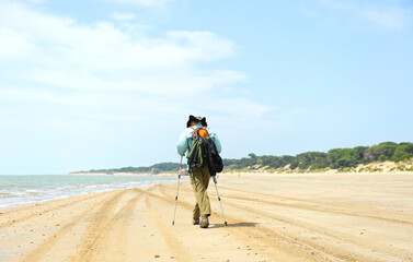 Senderismo en Doñana, España. Senderista caminando por la playa del Parque Nacional de Doñana, provincia de Huelva, Andalucía, España, 