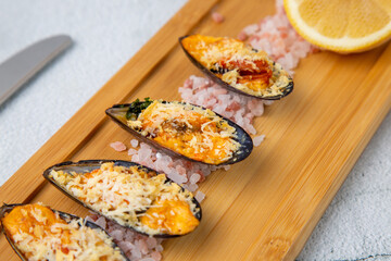 oysters scallops with red sea salt and citric acid on a wooden tray side view