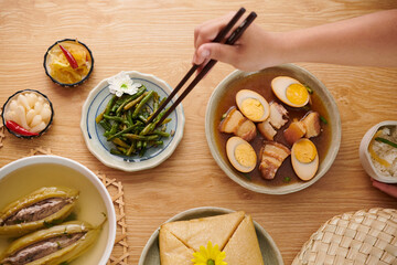 Person eating seared green beans and and praised pork at dinner table