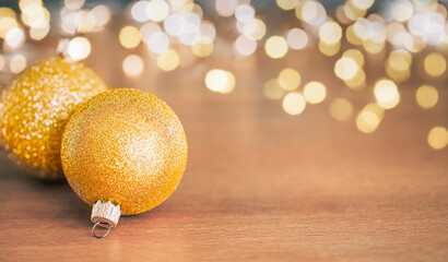 Christmas baubles with copy space on wooden background with blurred lights