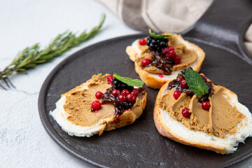 canapes with pate, mint leaves and berries, side view