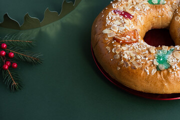 Spanish Christmas cake, Roscón de reyes, with traditional crown on green background. Dessert eaten...