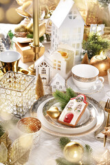 Christmas table setting with house theme decors in white and gold colors
