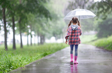 softfocus photo with the girl walking away along a foggy alley under an umbrella