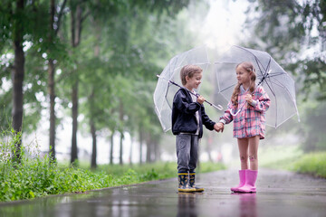 a little boy and a girl are talking outside under umbrellas after the rain - Powered by Adobe
