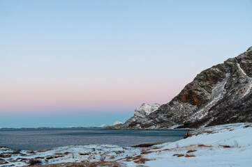 Fototapeta na wymiar Telephoto shot of the rugged norwegian coastline near Mjelle in the Arctic, during a brief golden hour.