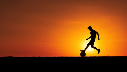 Fototapeta na wymiar A silhouette of a young football player playing with a ball at sunset.