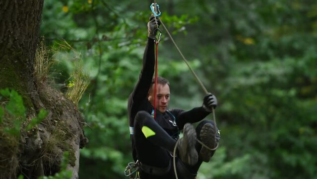 A climber with his equipment in a rocky mountain forest.
