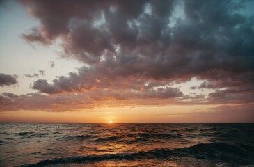 Fototapeta na wymiar Sunset horizon over ocean with waves and cloudy sky. 