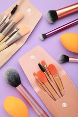 Professional female cosmetics brushes for makeup and eyelash brush on violet background. Cosmetics concept, make up concept. Vertical photo