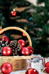 A rustic wooden basket cradling vibrant red decorative ornaments alongside miniature silver presents evoking the joy and anticipation of the holiday season 
