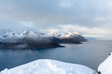 Aerial drone photo of snowy mountain hike up Segla in Senja, Norway.  Snowcapped mountains in the Arctic Circle of Northern Norway.  Famous hike on Senja island.  Shot in October
