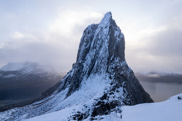 Aerial drone photo of snowy mountain hike up Segla in Senja, Norway.  Snowcapped mountains in the Arctic Circle of Northern Norway.  Famous hike on Senja island.  Shot in October.