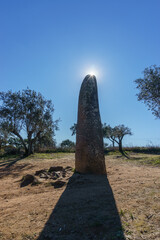 Menhir dos Almendres with sun on the blue sky near portuguese town Evora, Alentejo, Portugal